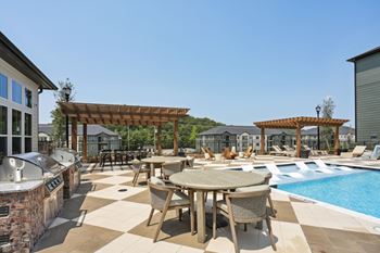 A poolside patio with a table and chairs